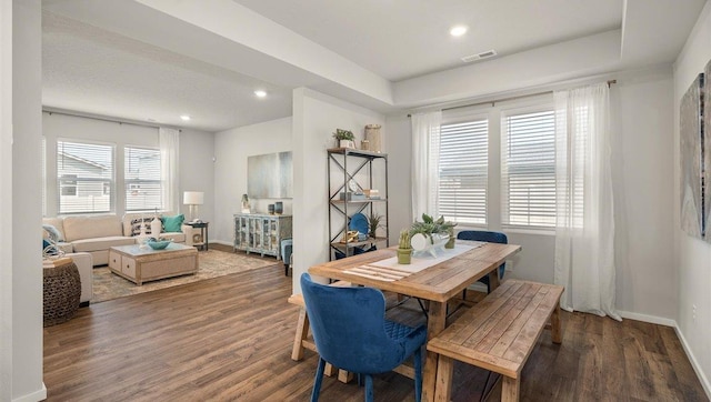 dining space with baseboards, visible vents, and wood finished floors