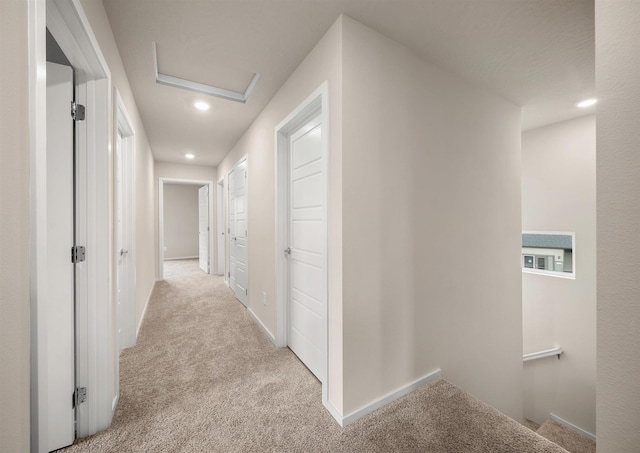 hall with carpet floors, attic access, baseboards, and recessed lighting