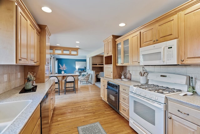 kitchen featuring white appliances, tasteful backsplash, glass insert cabinets, light wood-style floors, and recessed lighting