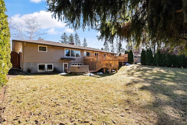 rear view of house featuring a yard, a chimney, a jacuzzi, a wooden deck, and stairs