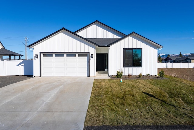 modern farmhouse featuring board and batten siding, concrete driveway, fence, and an attached garage