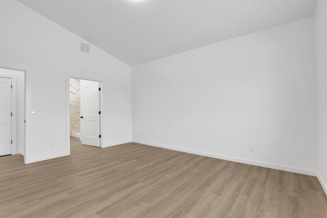 unfurnished room featuring high vaulted ceiling, light wood-type flooring, visible vents, and baseboards