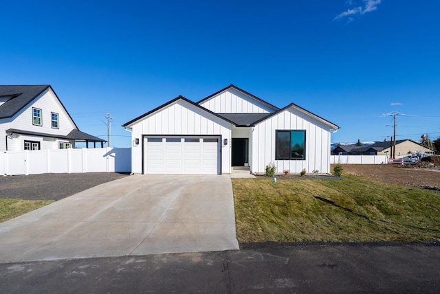 modern farmhouse style home with a garage, driveway, fence, a front lawn, and board and batten siding