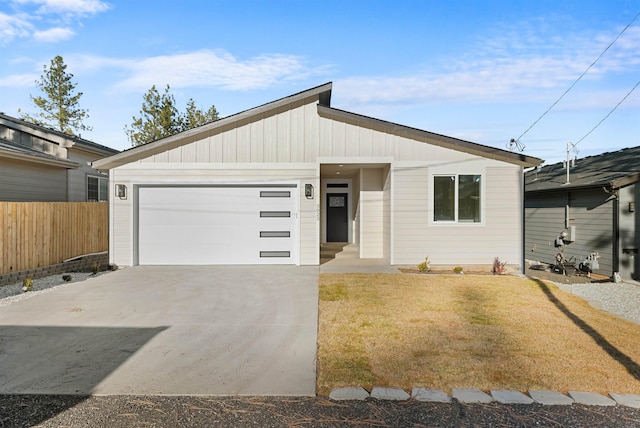 view of front facade featuring a garage, concrete driveway, fence, and a front lawn