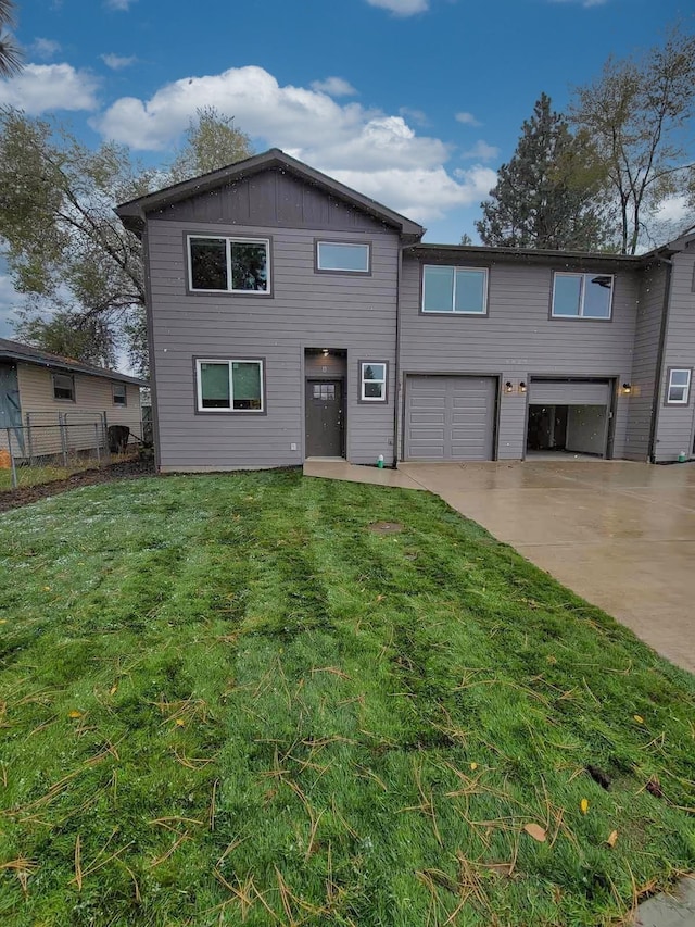 view of front of property with driveway, an attached garage, fence, a front lawn, and board and batten siding