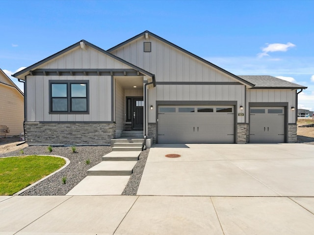 1624 S Moen St Unit 3/1Orchard, Spokane Valley, WA 99016 - view of front of house with stone siding, an attached garage, driveway, board and batten siding, and roof with shingles