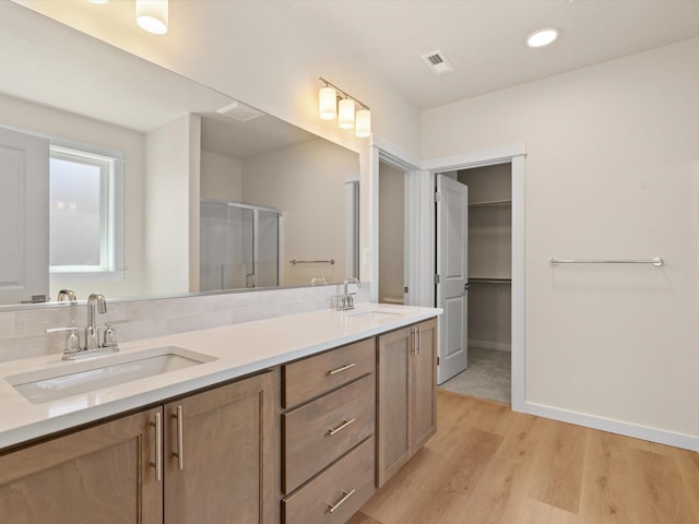 1624 S Moen St Unit 3/1Orchard, Spokane Valley, WA 99016 - bathroom with wood finished floors, double vanity, a shower with shower door, a walk in closet, and recessed lighting