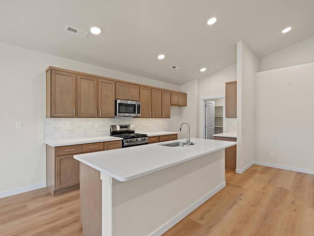 1624 S Moen St Unit 3/1Orchard, Spokane Valley, WA 99016 - kitchen featuring stainless steel appliances, backsplash, light wood-style flooring, light countertops, and a kitchen island with sink