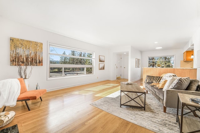 living area featuring light wood-style floors, recessed lighting, and baseboards