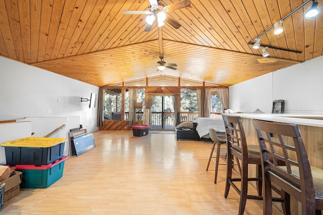 interior space featuring vaulted ceiling, wood finished floors, wood ceiling, and rail lighting