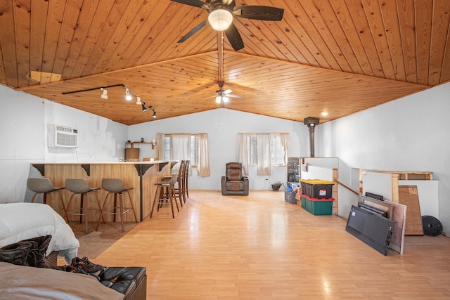 living area with lofted ceiling, wooden ceiling, a wall unit AC, and wood finished floors