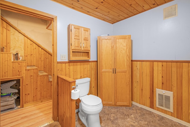 bathroom with wood walls, wainscoting, and visible vents