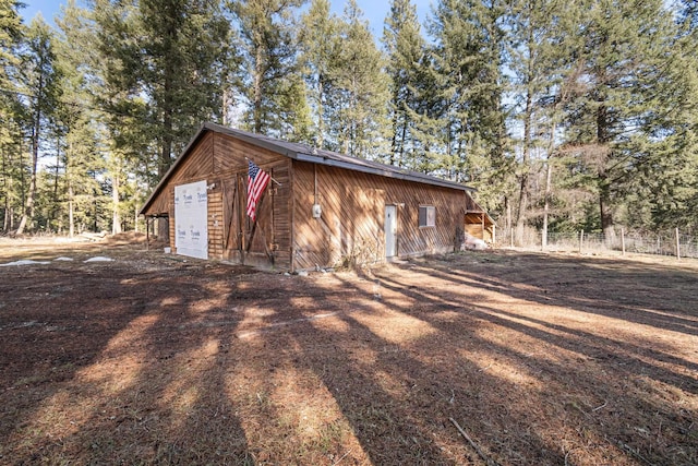 exterior space featuring fence and an outbuilding