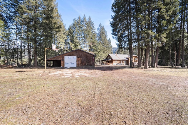 view of yard with a detached garage and an outdoor structure