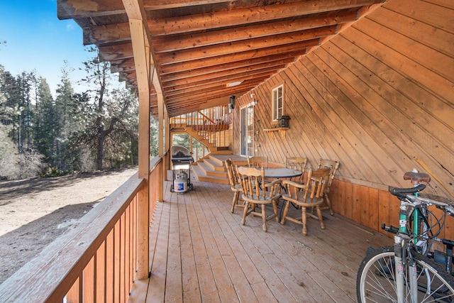 wooden terrace featuring grilling area and outdoor dining area