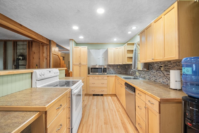 kitchen with light wood finished floors, stainless steel appliances, backsplash, light brown cabinetry, and a sink