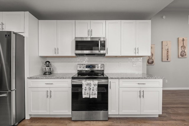 kitchen with appliances with stainless steel finishes, white cabinets, decorative backsplash, and light stone counters