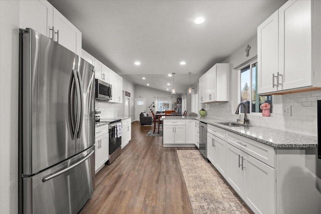 kitchen with stainless steel appliances, dark wood-type flooring, a sink, white cabinetry, and open floor plan