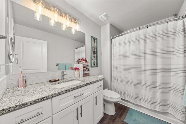 full bath with visible vents, toilet, wood finished floors, vanity, and backsplash