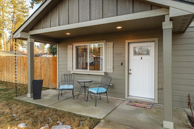 entrance to property with board and batten siding and fence