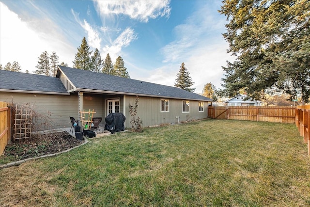 rear view of property with a lawn and a fenced backyard