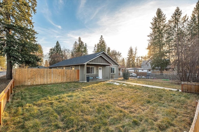 exterior space with board and batten siding, fence private yard, and a front lawn