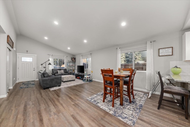 dining space featuring vaulted ceiling, wood finished floors, and recessed lighting