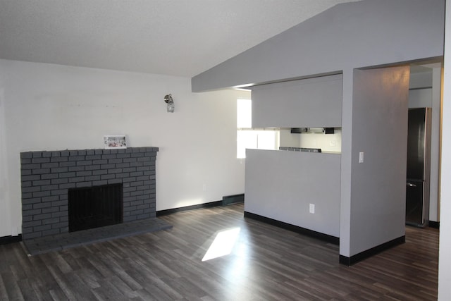 unfurnished living room with a brick fireplace, vaulted ceiling, baseboards, and wood finished floors