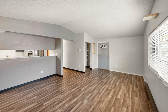 102 E Weile Ave # 3, Spokane, WA 99208 - unfurnished living room with a textured ceiling, vaulted ceiling, wood finished floors, and baseboards