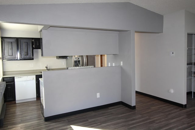 kitchen featuring lofted ceiling, dark wood-style flooring, baseboards, light countertops, and dishwasher