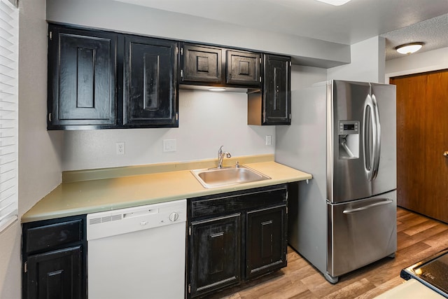 102 E Weile Ave # 3, Spokane, WA 99208 - kitchen with a sink, light wood-style floors, white dishwasher, dark cabinetry, and stainless steel fridge with ice dispenser
