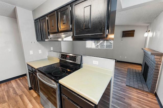 102 E Weile Ave # 3, Spokane, WA 99208 - kitchen featuring stainless steel range with electric cooktop, light wood-style floors, under cabinet range hood, light countertops, and baseboards