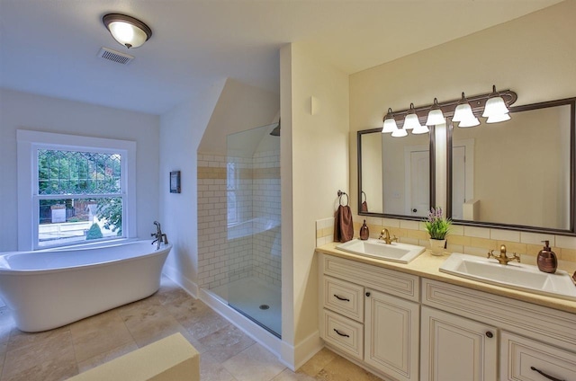 2508 S Grand Blvd, Spokane, WA 99203 - bathroom featuring double vanity, a tile shower, a freestanding tub, and baseboards
