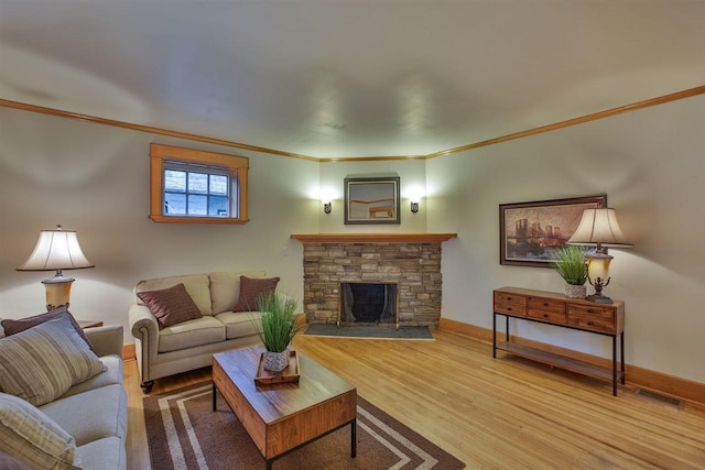 living room with crown molding, a fireplace, visible vents, wood finished floors, and baseboards