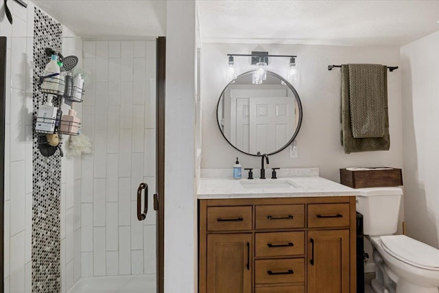 full bath with toilet, a shower stall, a textured ceiling, and vanity