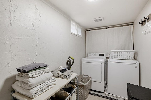 washroom with laundry area, visible vents, and washer and clothes dryer