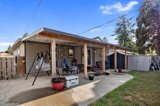 back of property with a storage shed, fence, a yard, a patio area, and an outdoor structure