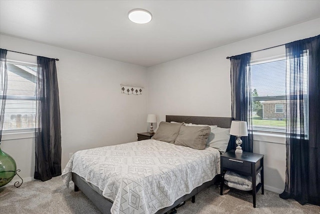 carpeted bedroom with multiple windows and baseboards