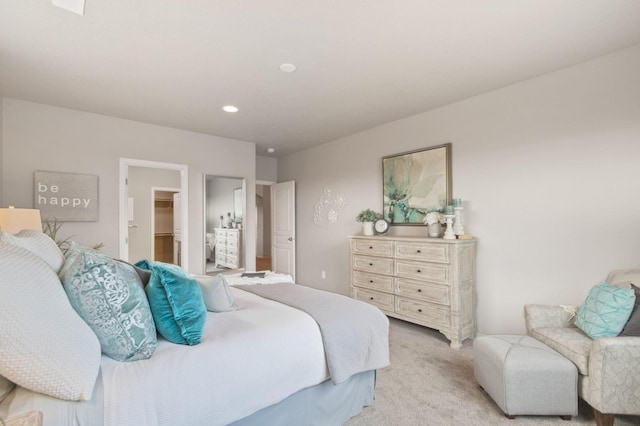 bedroom featuring recessed lighting, a walk in closet, and light colored carpet