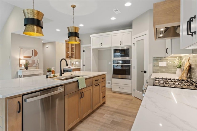 kitchen featuring tasteful backsplash, visible vents, appliances with stainless steel finishes, light wood-style floors, and a sink