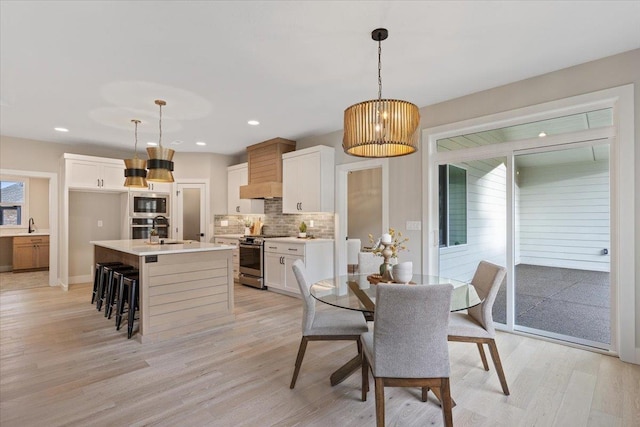 dining area featuring baseboards, light wood-style flooring, and recessed lighting