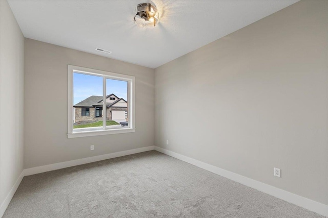 unfurnished room featuring carpet floors, visible vents, and baseboards