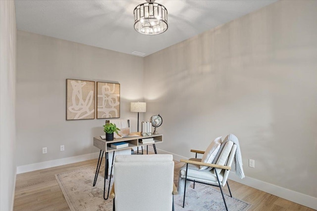 office with an inviting chandelier, wood finished floors, and baseboards