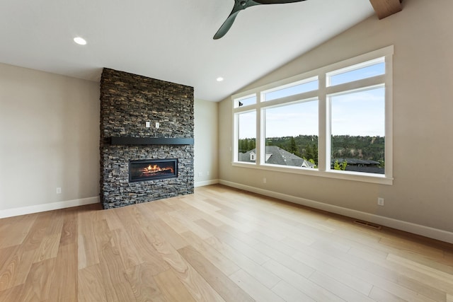 unfurnished living room with visible vents, baseboards, wood finished floors, vaulted ceiling, and a fireplace