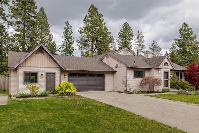 view of front of house featuring roof with shingles, board and batten siding, a front yard, a garage, and driveway