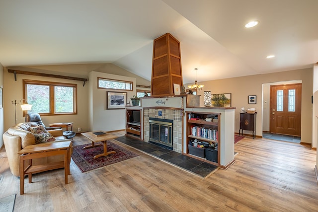 living room featuring baseboards, wood finished floors, vaulted ceiling, a fireplace, and recessed lighting