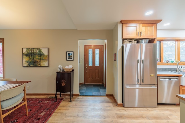 kitchen featuring light wood finished floors, baseboards, appliances with stainless steel finishes, light countertops, and recessed lighting