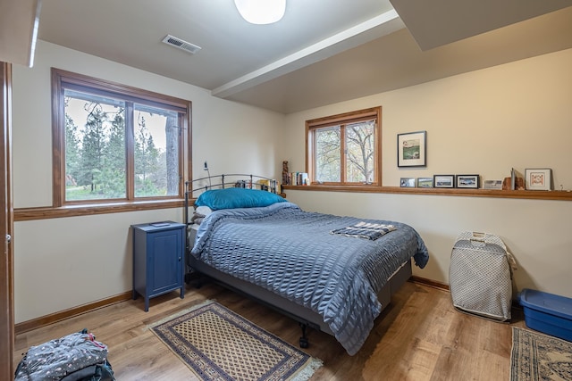 bedroom with light wood-type flooring, multiple windows, and visible vents