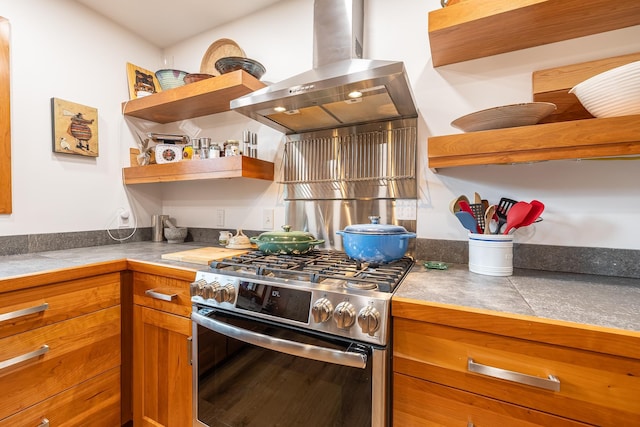 kitchen featuring open shelves, stainless steel gas range oven, brown cabinets, and island range hood