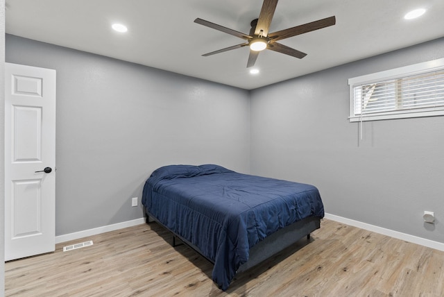 bedroom featuring light wood-type flooring, visible vents, and baseboards